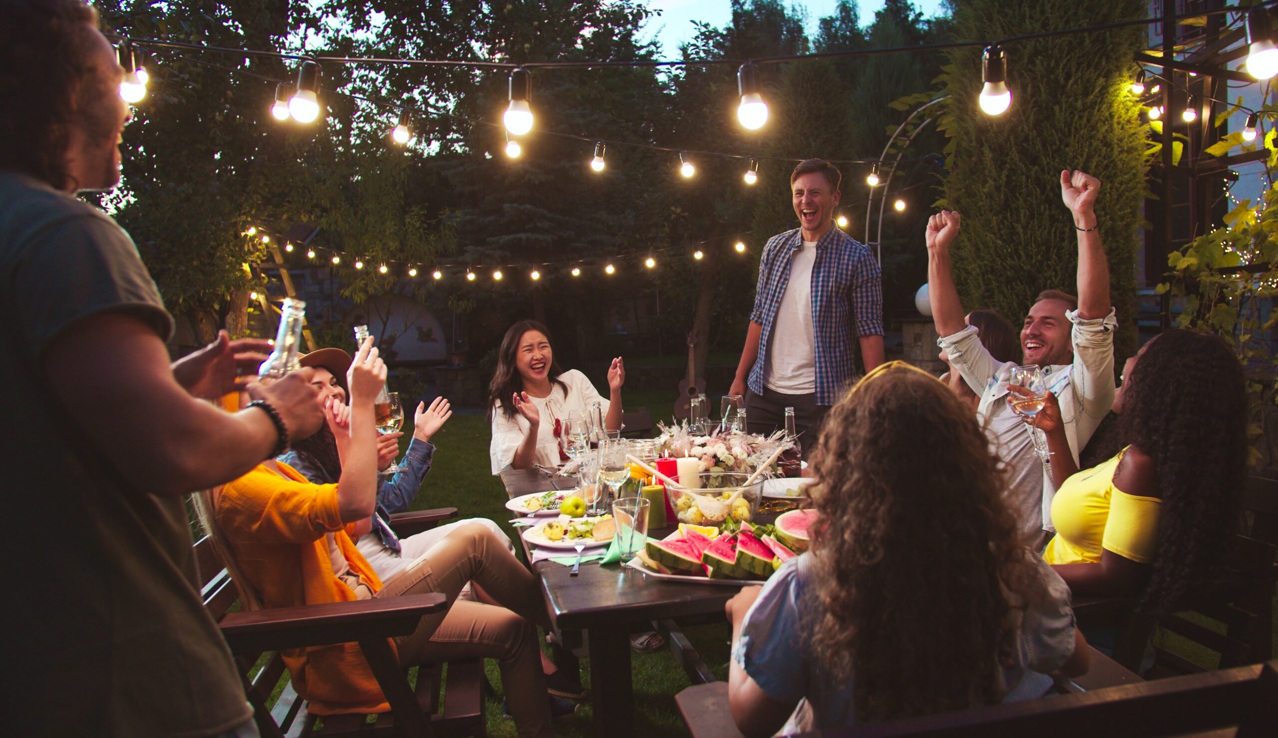 Friends enjoying each other outside around table.